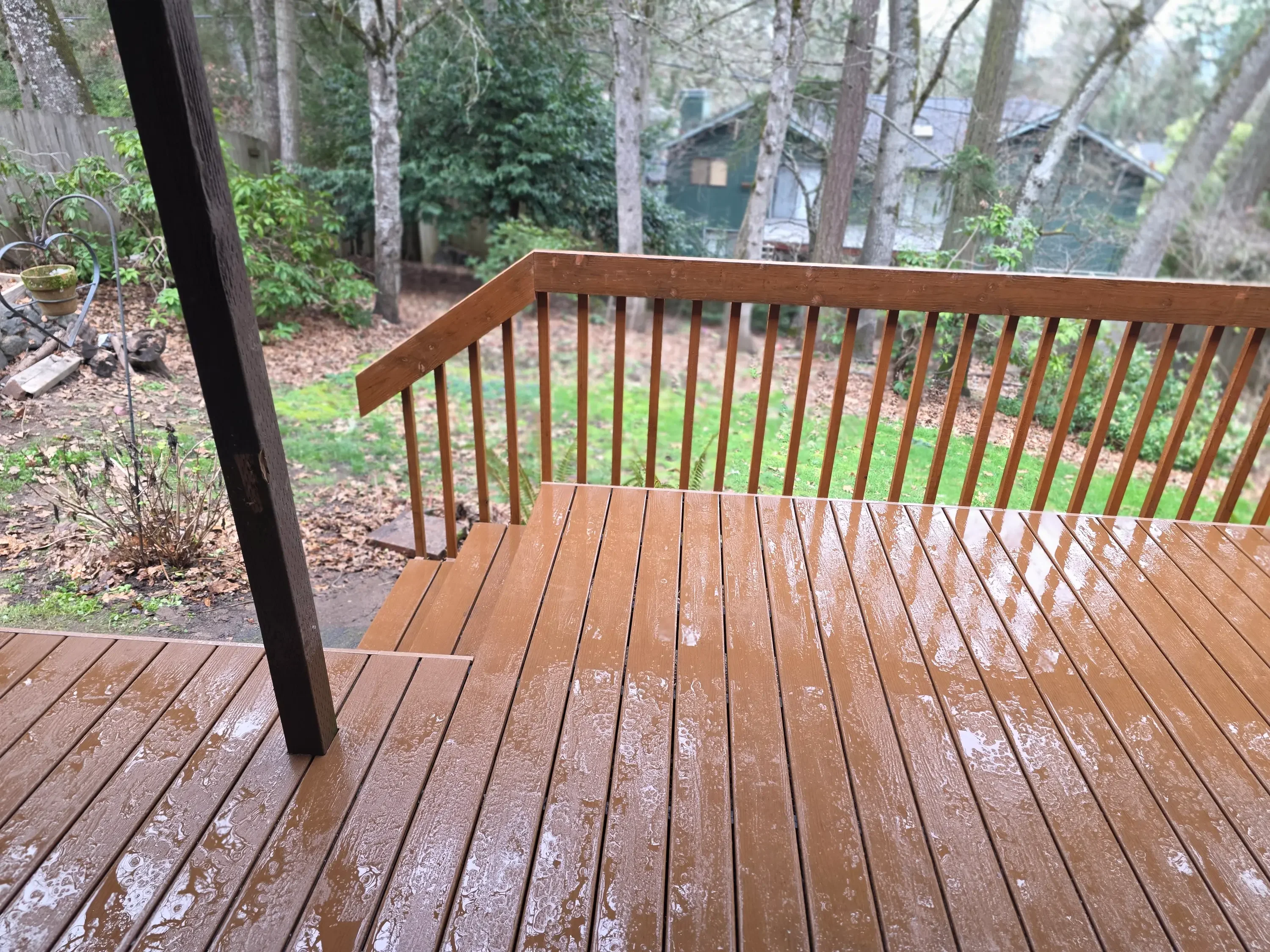 Pressure-treated wood deck with vertical spindle railing overlooking wooded yard