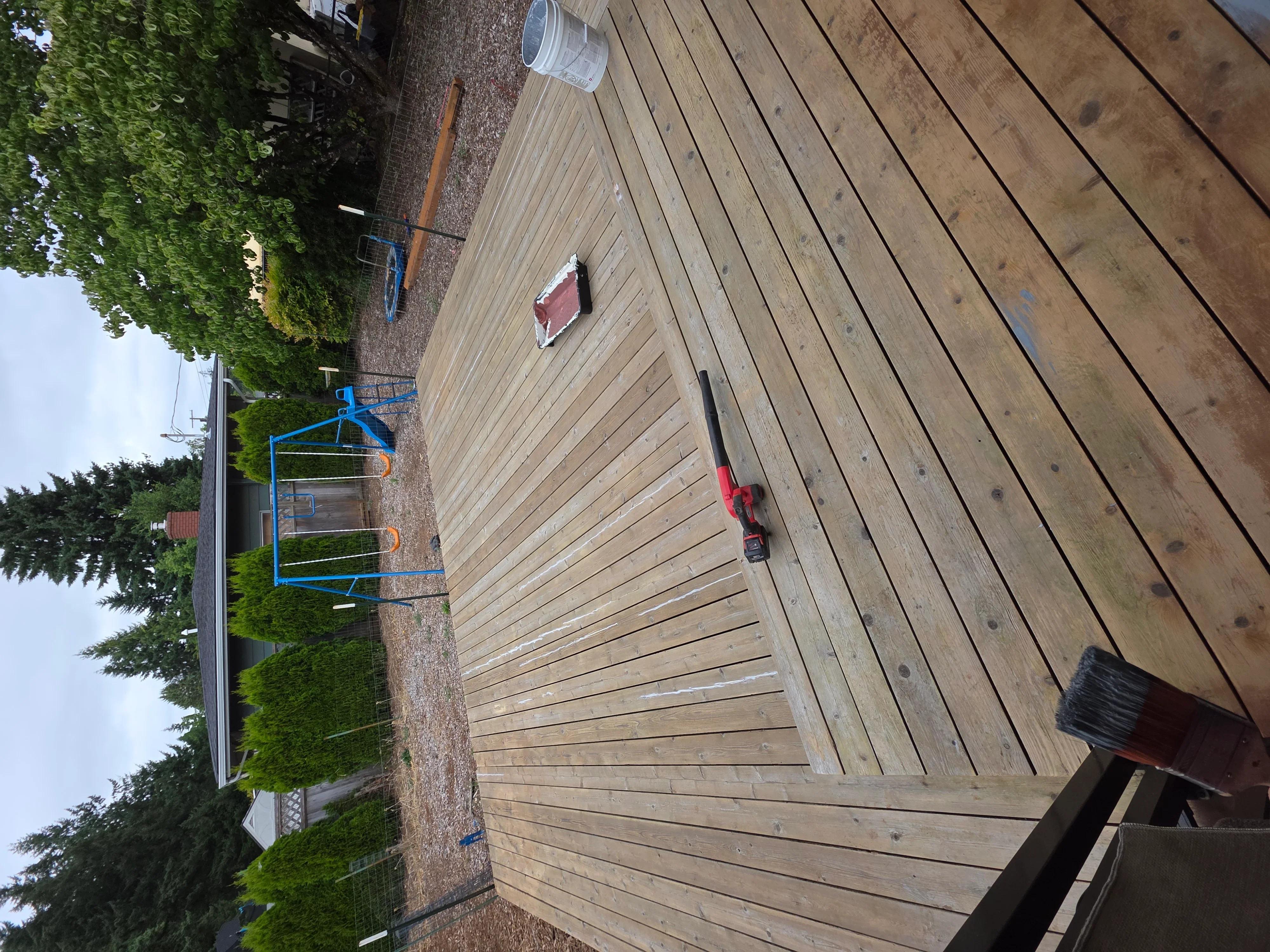Newly installed pressure-treated wood deck with linear board pattern and fasteners