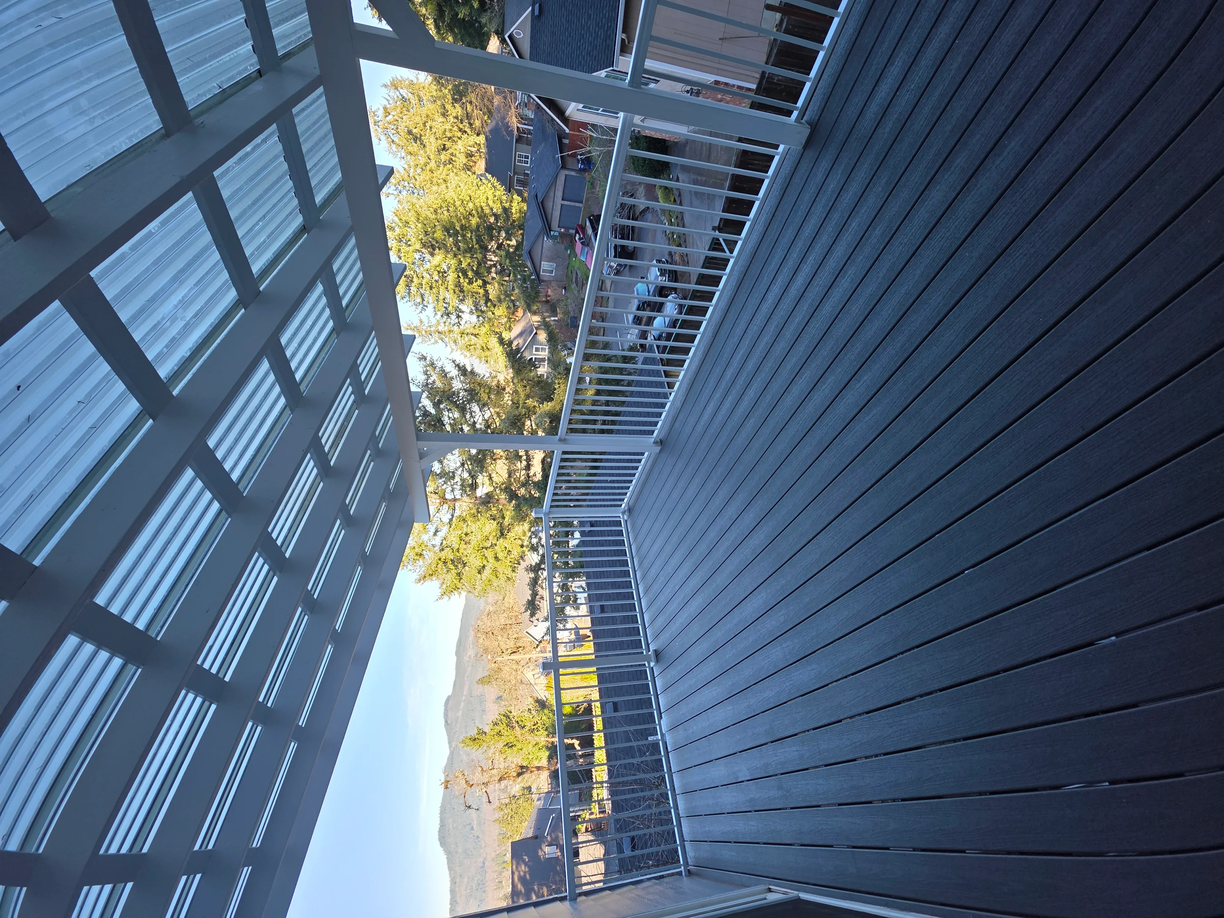 Metal frame staircase with composite decking and cable railings between two buildings