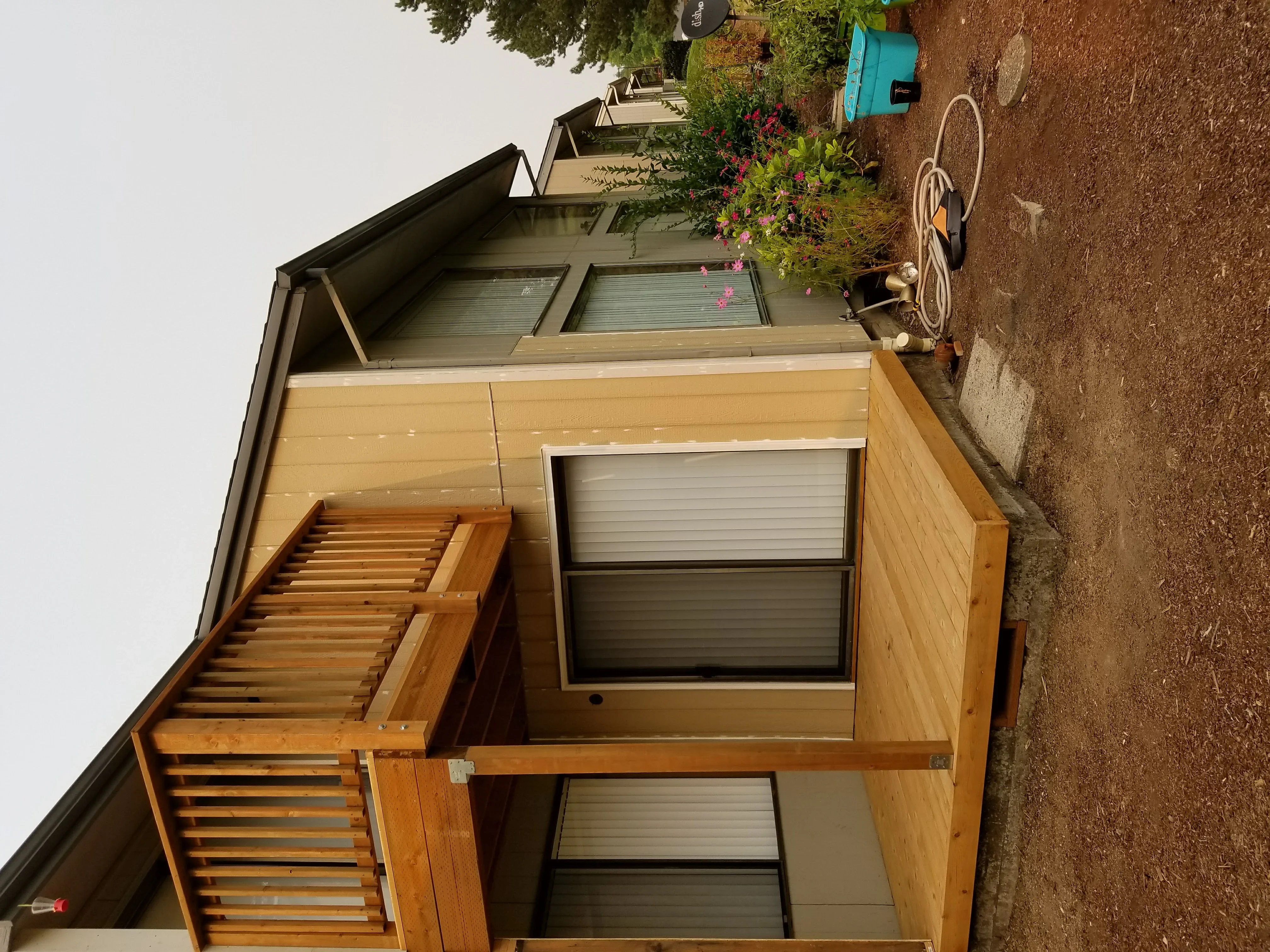 Cedar-sided garage addition with shed roof, louvered vents, and metal roofing