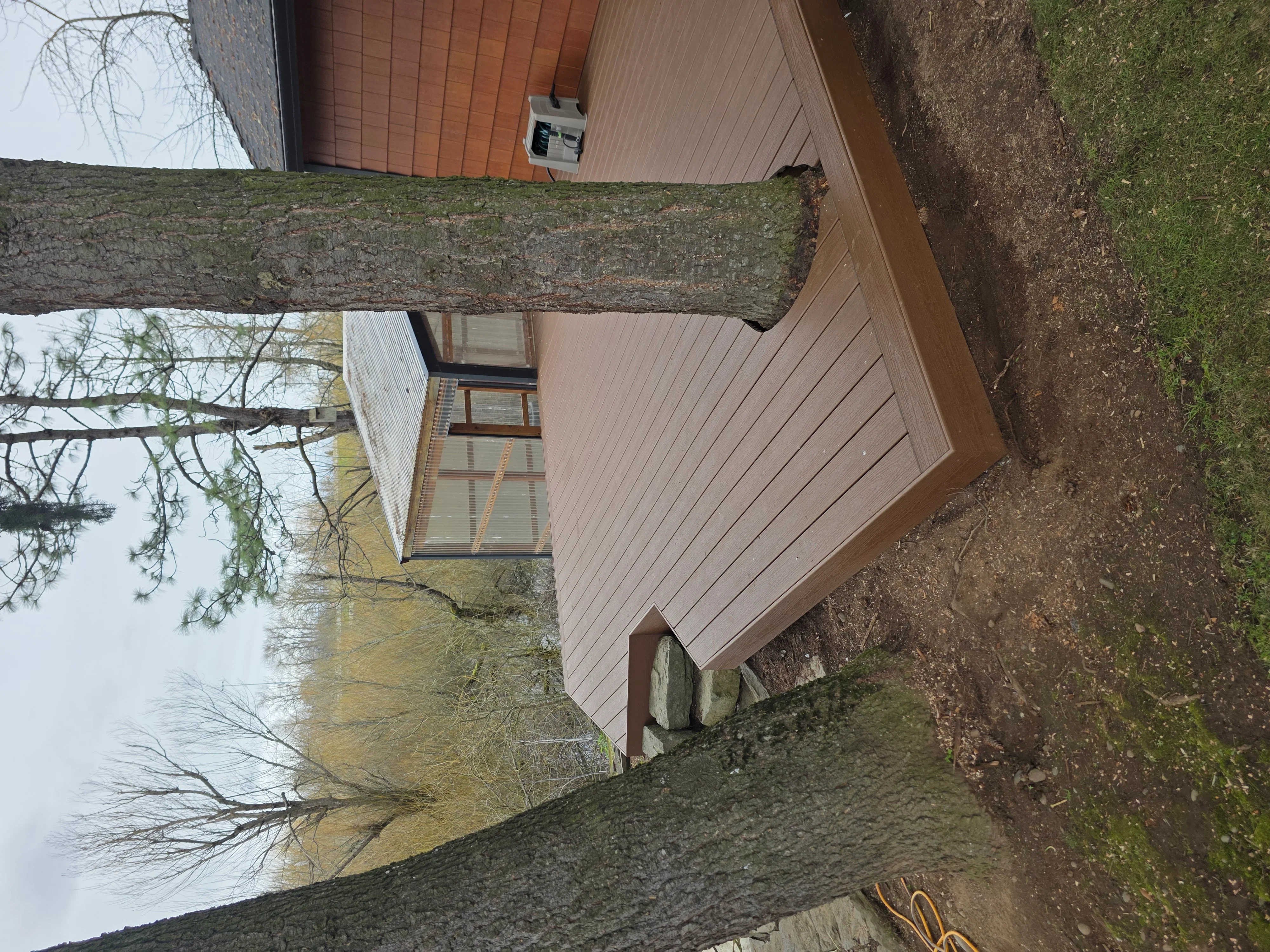New vertical fiber cement siding with soffit and trim installation on residential home