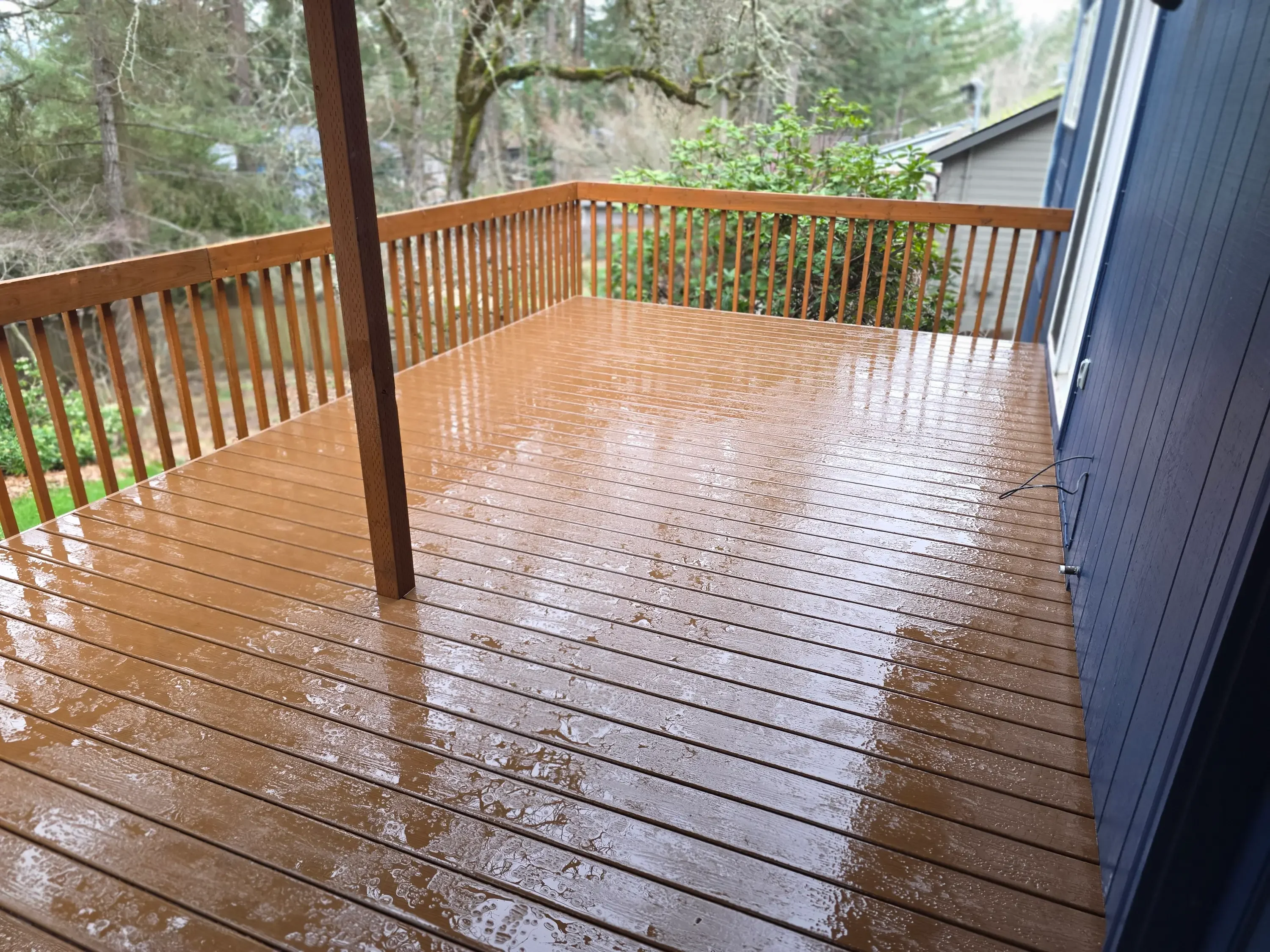 Newly constructed wooden deck with stained boards and vertical railing spindles