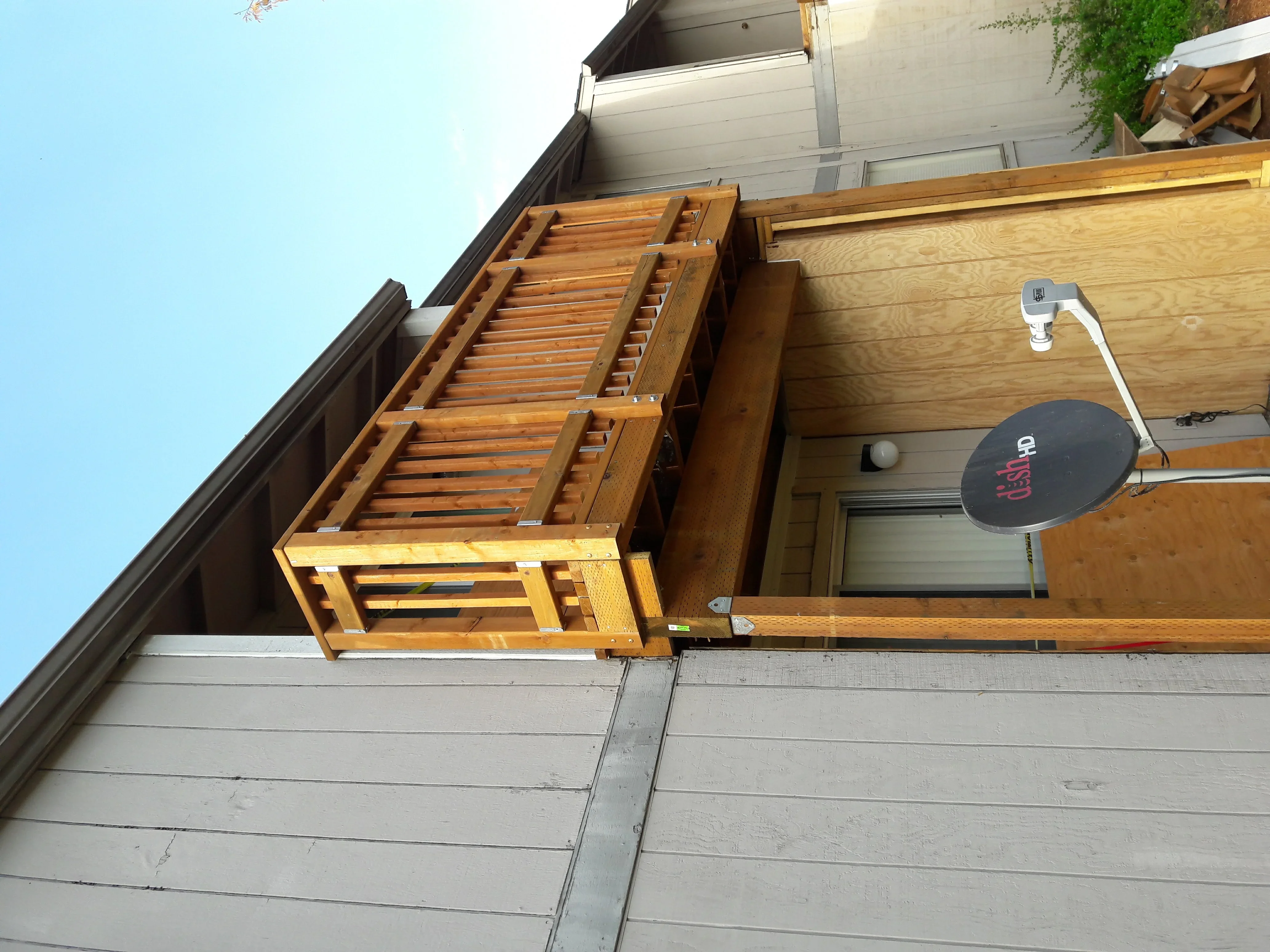 Wood soffit and fascia with horizontal slats, metal trim, and ventilation installed on residential eave