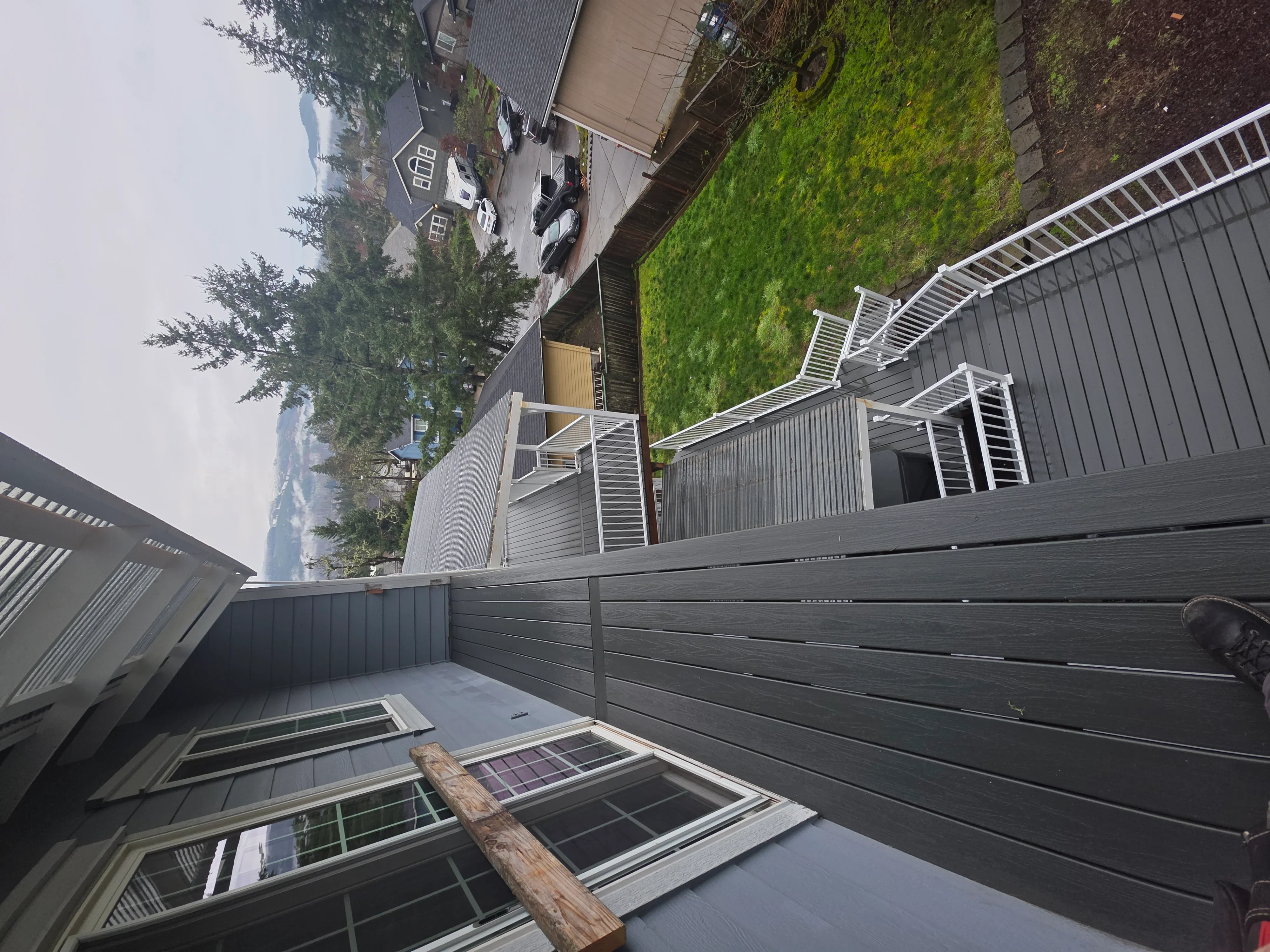 Composite deck with cable railing and horizontal gray fence installation